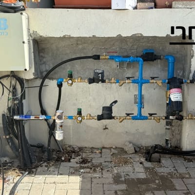 צנרת מים עם ברזים ומדי לחץ על קיר חיצוני