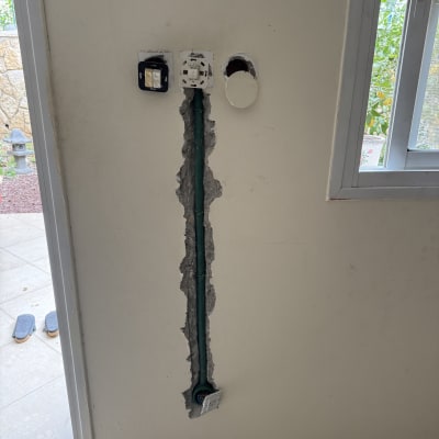 שקעי חשמל על קיר עם חוטים חשופים