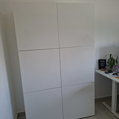 ארון לבן עם דלתות חלקות ליד שולחן