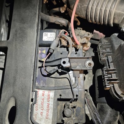 מצבר רכב עם כבלים מחוברים בתא המנוע