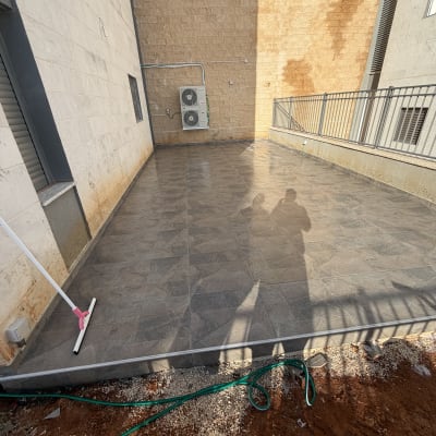 ריצוף חדש בחצר עם צינור השקיה ומגב