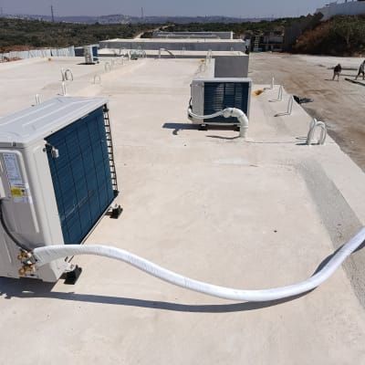 יחידות מיזוג אוויר על גג בטון עם צינורות מחוברים