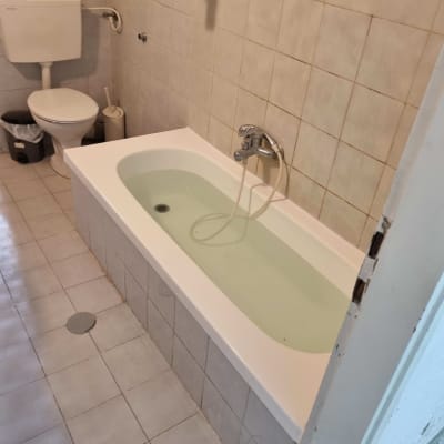 אמבטיה עם מים בחדר רחצה פשוט