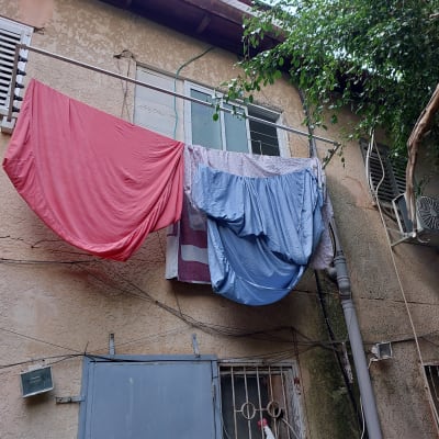 כביסה תלויה על חבל ליד חלון בניין