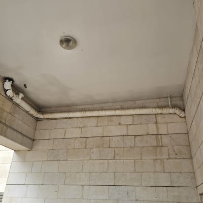 תקרה עם צינור מבודד ומנורה עגולה