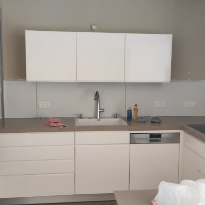 מטבח בשיפוץ עם ארונות לבנים וכיור מותקן