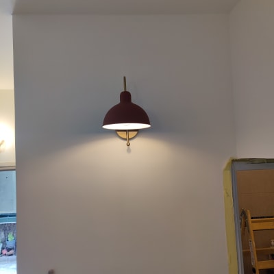 מנורת קיר דולקת על קיר לבן