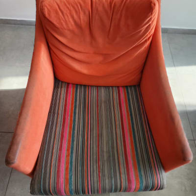 כורסה כתומה עם מושב פסים צבעוני