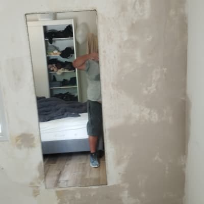 קיר עם טיח חלקי ומראה