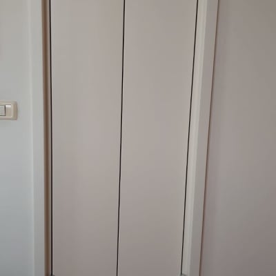 דלת עץ עם צירים מתכתיים על קיר לבן