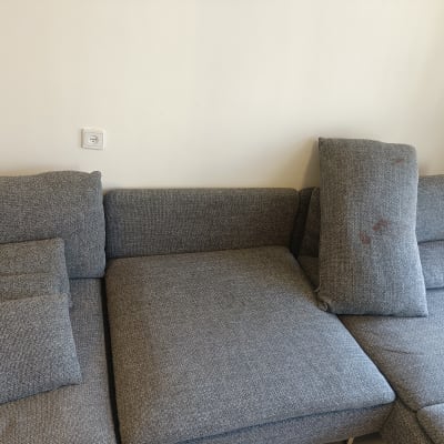 ספה אפורה עם כתמים על כרית אחת