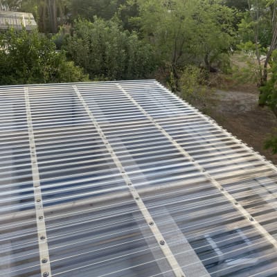 גג פלסטיק שקוף עם קורות עץ בגינה