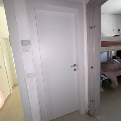 דלת לבנה בחדר פנימי עם ידית כסופה