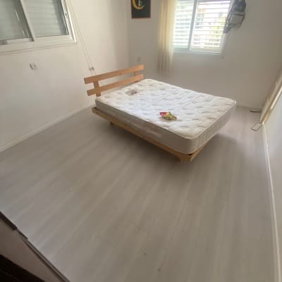 רצפת פרקט בחדר שינה עם מיטה ללא מצעים