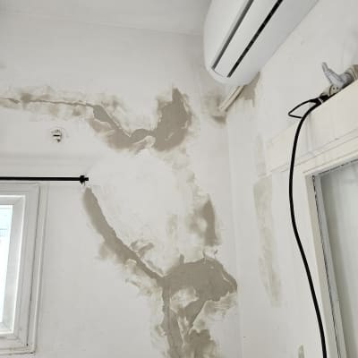 חלון עם תריסים סגורים ליד קיר מתוקן