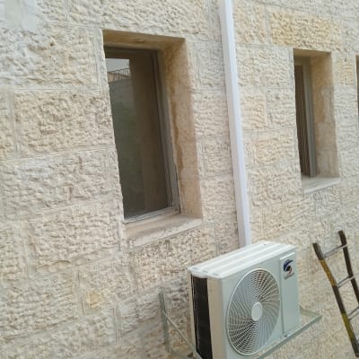 יחידת מיזוג אוויר מותקנת על קיר אבן חיצוני