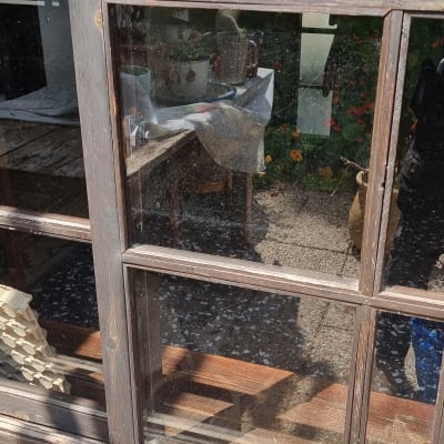 חלון זכוכית עם מסגרת עץ, השתקפות חפצים בפנים