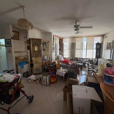 חדר מבולגן עם קופסאות וציוד לניקוי