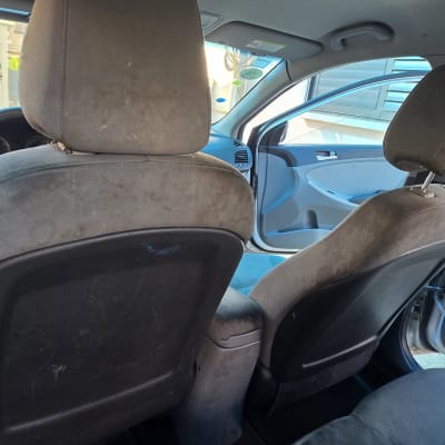 ניקוי מושבים ברכב עם כפפה כחולה