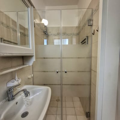 מקלחון זכוכית עם ראש מקלחת מתכתי