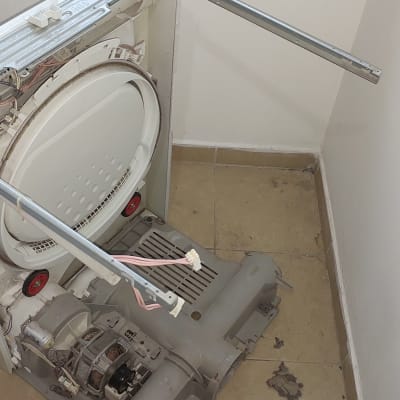 מכונת כביסה פתוחה עם תוף חשוף וחוטי חשמל