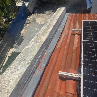 דוקרנים על גג למניעת יונים ליד פאנלים סולאריים