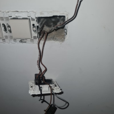 חוטי חשמל חשופים בקיר עם מתג מפורק