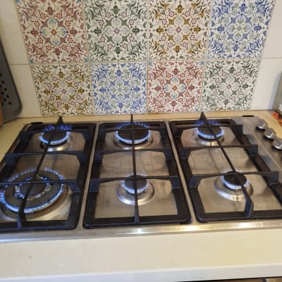 כיריים גז עם להבות דולקות על משטח מטבח
