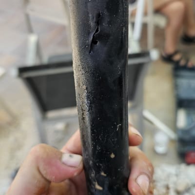 צינור שחור עם חור מוחזק ביד, רקע מטושטש