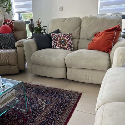 ספה בהירה עם כריות צבעוניות בסלון מואר