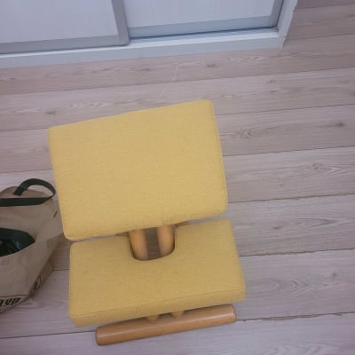 כיסא מרופד בצבע צהוב עם רגלי עץ