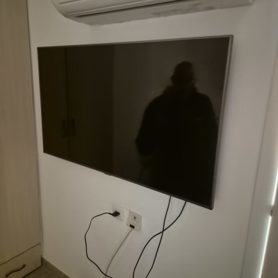 טלוויזיה מותקנת על הקיר עם חוטים מחוברים