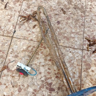 גוף חימום ישן ומלוכלך על רצפה מרוצפת