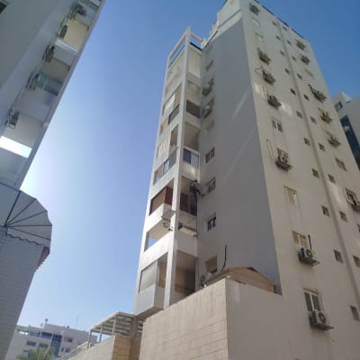 אדם עובד על בניין גבוה, כנראה בתחום הסרת יונים