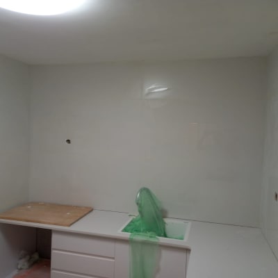 ארון מטבח לבן עם משטח עץ ויריעת פלסטיק ירוקה