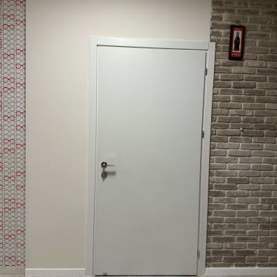 דלת לבנה על רקע קיר לבנים וטפט מעוצב