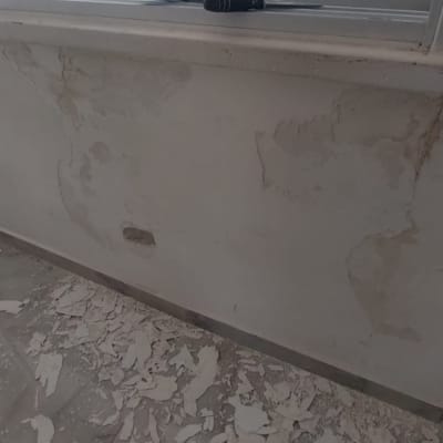 קיר מתקלף עם כלים על אדן החלון