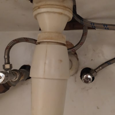 צינורות מתכת וברזים מתחת לכיור