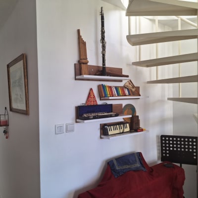 מדרגות לולייניות ליד מדף עם כלי נגינה