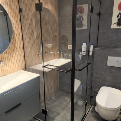 מקלחון זכוכית עם ראש מקלחת עגול ומדף מוצרים