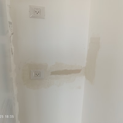 שני שקעים חשמליים בקיר עם תיקוני טיח
