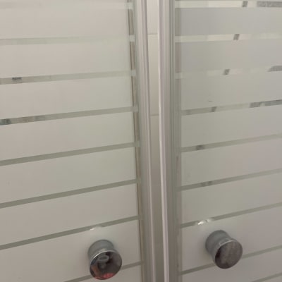 דלתות זכוכית עם ידיות מתכת במקלחת