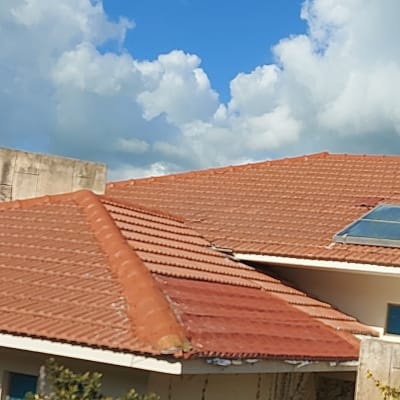 גג רעפים אדום עם לוח סולארי קטן