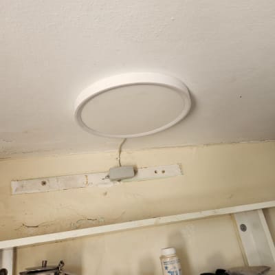 מנורת תקרה עגולה מחוברת לתקרה עם חוט חשמל