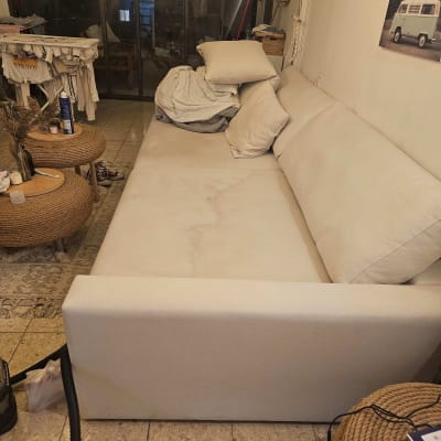 ספה בהירה עם כריות בחדר מגורים