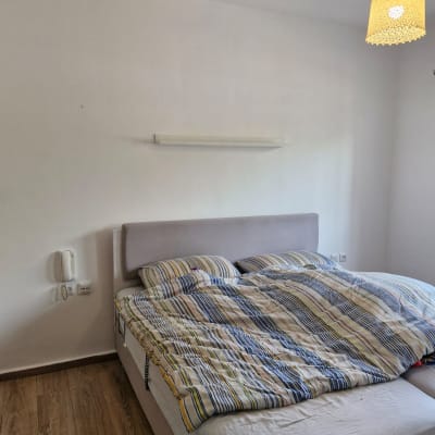 מיטה עם מצעים צבעוניים בחדר שינה פשוט