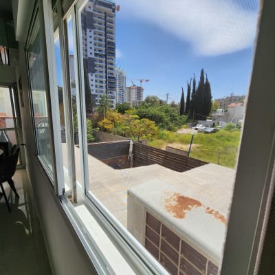 חלון אלומיניום פתוח עם נוף חיצוני