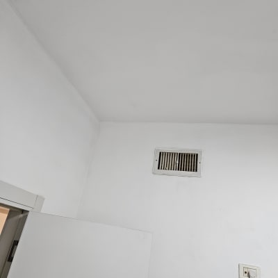 קיר ותקרה צבועים בלבן עם פתח אוורור