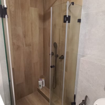 מקלחון זכוכית עם ראש מקלחת עגול ואריחי עץ