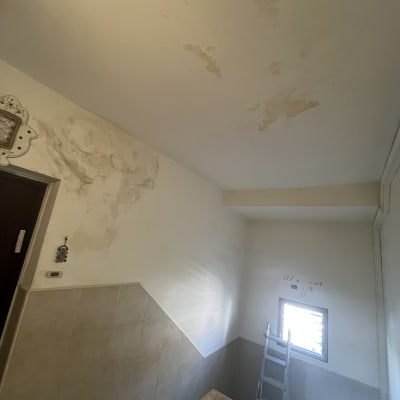 קיר ותקרה עם סימני רטיבות ותיקונים